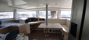 Schiffsinnenraum mit Schreibtisch, Bedienfeld und Sitzgelegenheit.