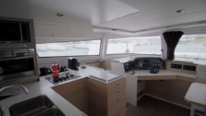 Cocina compacta con estufa, cafetera y vista al agua.