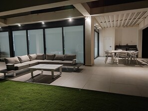 A modern living room with a sectional sofa, a coffee table, and a dining area with chairs and a table. - Golf course villa for 8–10 people with ocean views, 8 minutes from the beaches (Bonmont Terres Noves)