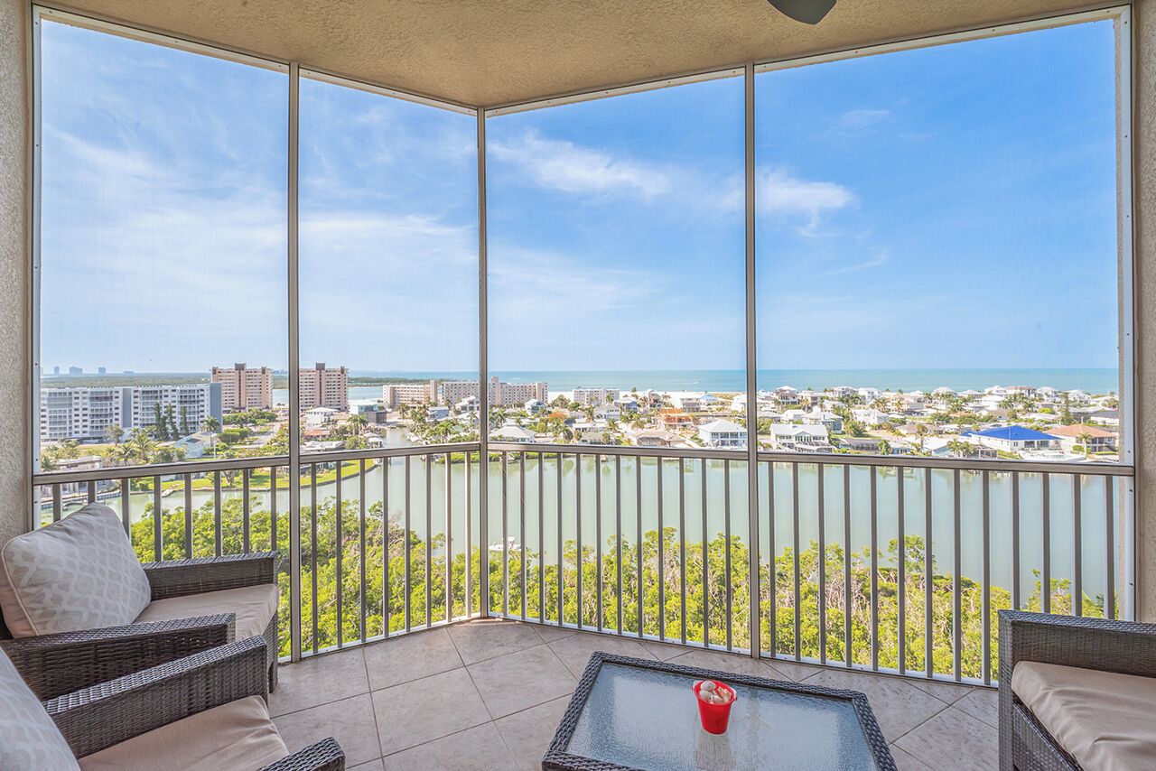A balcony with a view of a cityscape and a body of water.
