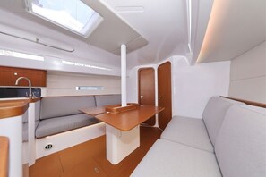 Ein kompakter Innenraum mit Küchenzeile, Sitzecke und Fenster für natürliches Licht.