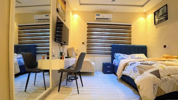Un dormitorio con escritorio, dos camas y un espejo.