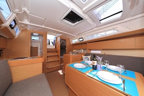 A compact RV interior with a dining area, a kitchenette, and a sleeping area. - Sun-Kissed Sailing Adventure in Istria, Croatia (Pula)