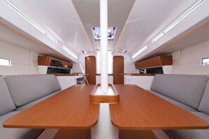 Un interior modern amb una taula central, dos sofàs i una zona de cuina.