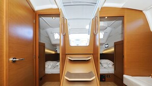 Kompakt autocamper indretning med to soveområder, et tekøkken og et lille badeværelse.