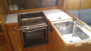 A compact kitchenette with a stove, oven, and sink.