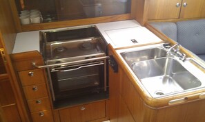 A compact kitchenette with a stove, oven, and sink.
