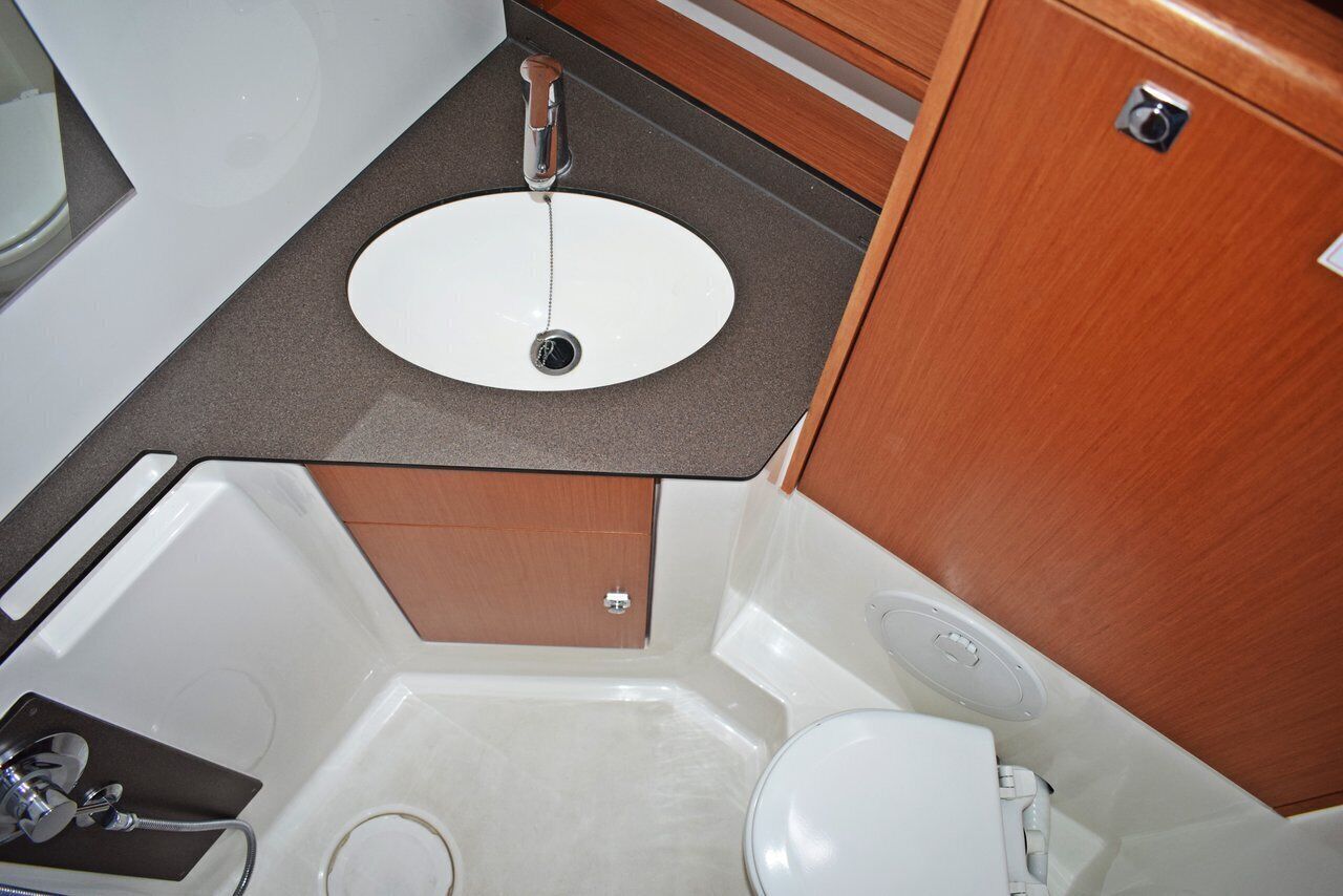 Ein kleines Badezimmer mit einem weißen Waschbecken, einer Badewanne und einer Toilette.