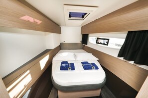 A compact, well-lit room with a bed, a small window, and a mounted TV. - Sun-kissed Sailing Adventure in Split-Dalmatia, Croatia (Trogir)