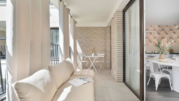 A balcony with a sofa, a dining table, and chairs. - Unique 2-Bedroom Apartment Balcony Parking (Poznań)