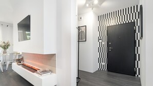 A modern interior with a fireplace, a black and white patterned wall, and a dark door. - Unique 2-Bedroom Apartment Balcony Parking (Poznań)