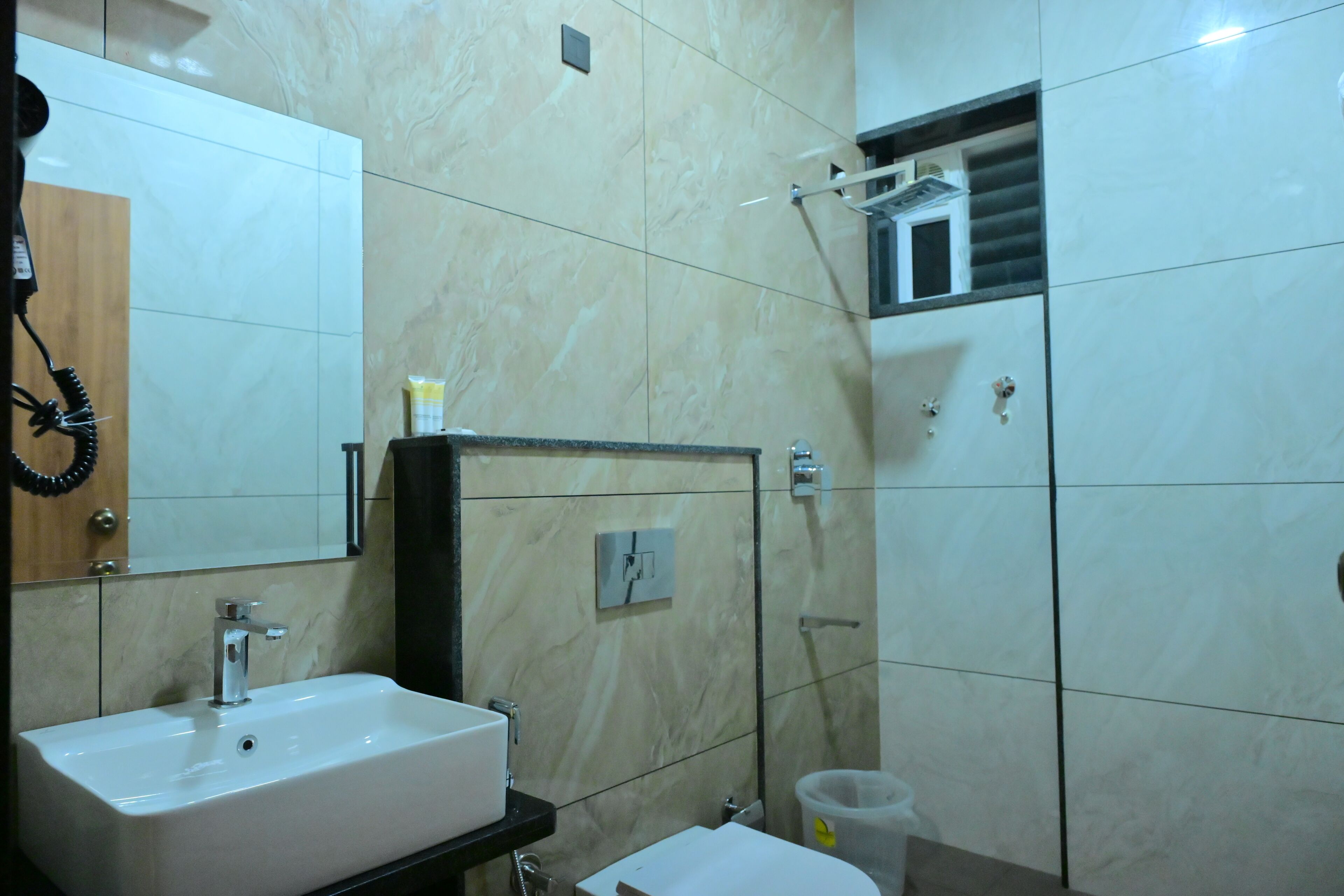 A bathroom with a sink, mirror, shower, and toilet.