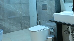 Un baño moderno con inodoro, lavabo y zona de ducha.