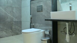 Un baño moderno con inodoro, bidé y lavamanos.
