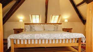 Quarto com uma cama de madeira, duas luminárias de cabeceira e uma janela.