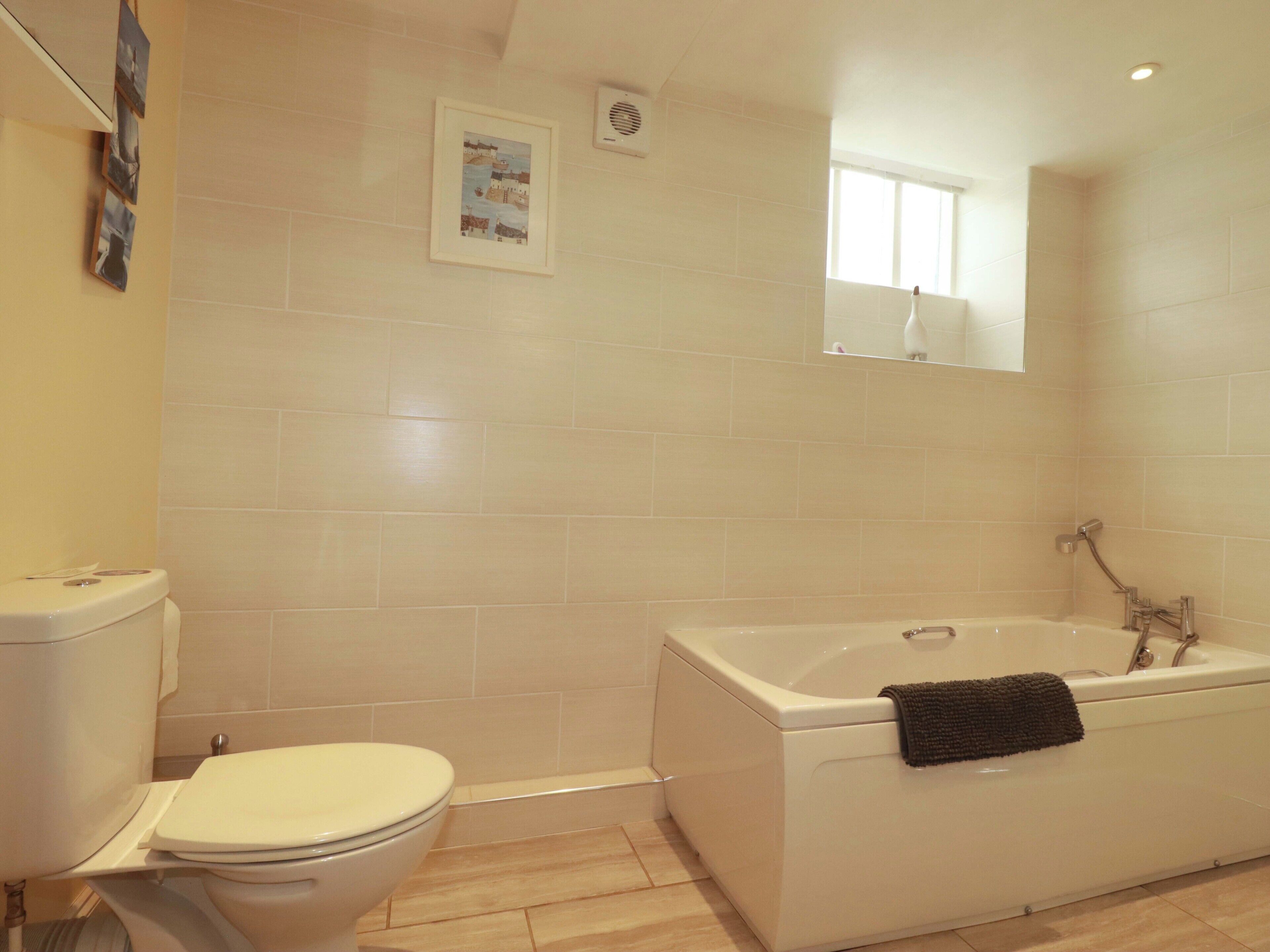 A bathroom with a toilet, a bathtub, and a shower.