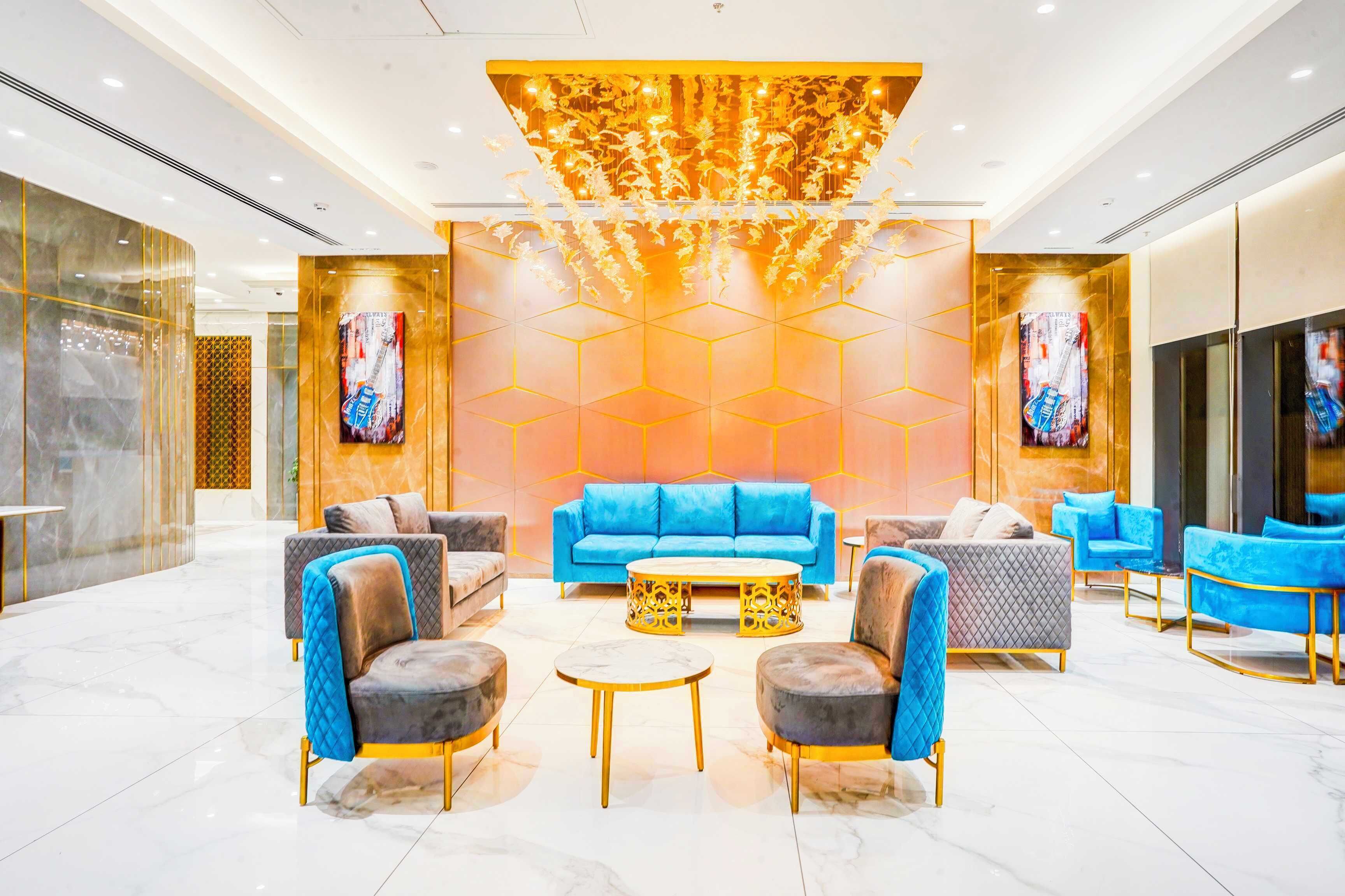 A modern lobby with a blue sofa, armchairs, and a coffee table.