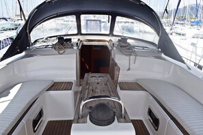 A boat's deck with a central seating area, windows, and a view of other boats. - Sun-Kissed Sailing Adventure in Split, Croatia (Kaštel Gomilica)