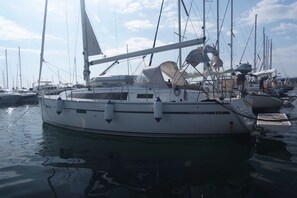 Ein Segelboot liegt in einer Marina, wo sich mehrere andere Boote befinden.