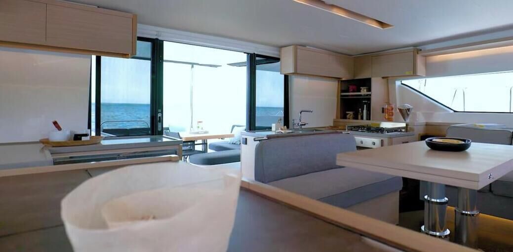 Une cuisine moderne avec un coin repas, de grandes fenêtres et une vue sur la mer.