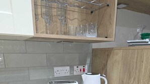 A kitchen with a toaster, a coffee maker, and a wine rack. - Elysea Haven 3 Bedroom house, newly renovated (Leeds)