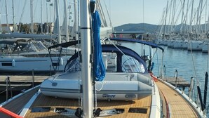 A wooden deck with a blue rope, a mast, and a marina in the background. - Sun-kissed Sailing Adventure in Split-Dalmatia, Croatia (Trogir)