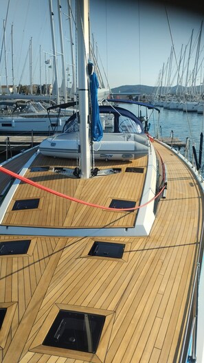 A wooden deck with a blue rope, a mast, and a marina in the background. - Sun-kissed Sailing Adventure in Split-Dalmatia, Croatia (Trogir)