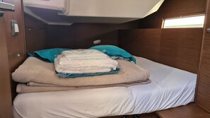 Ein kleines Blockhäuschen mit Etagenbett, kleinem Fenster und Bedienfeld.