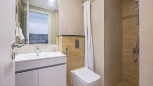 Un bagno moderno con lavandino, specchio e doccia.
