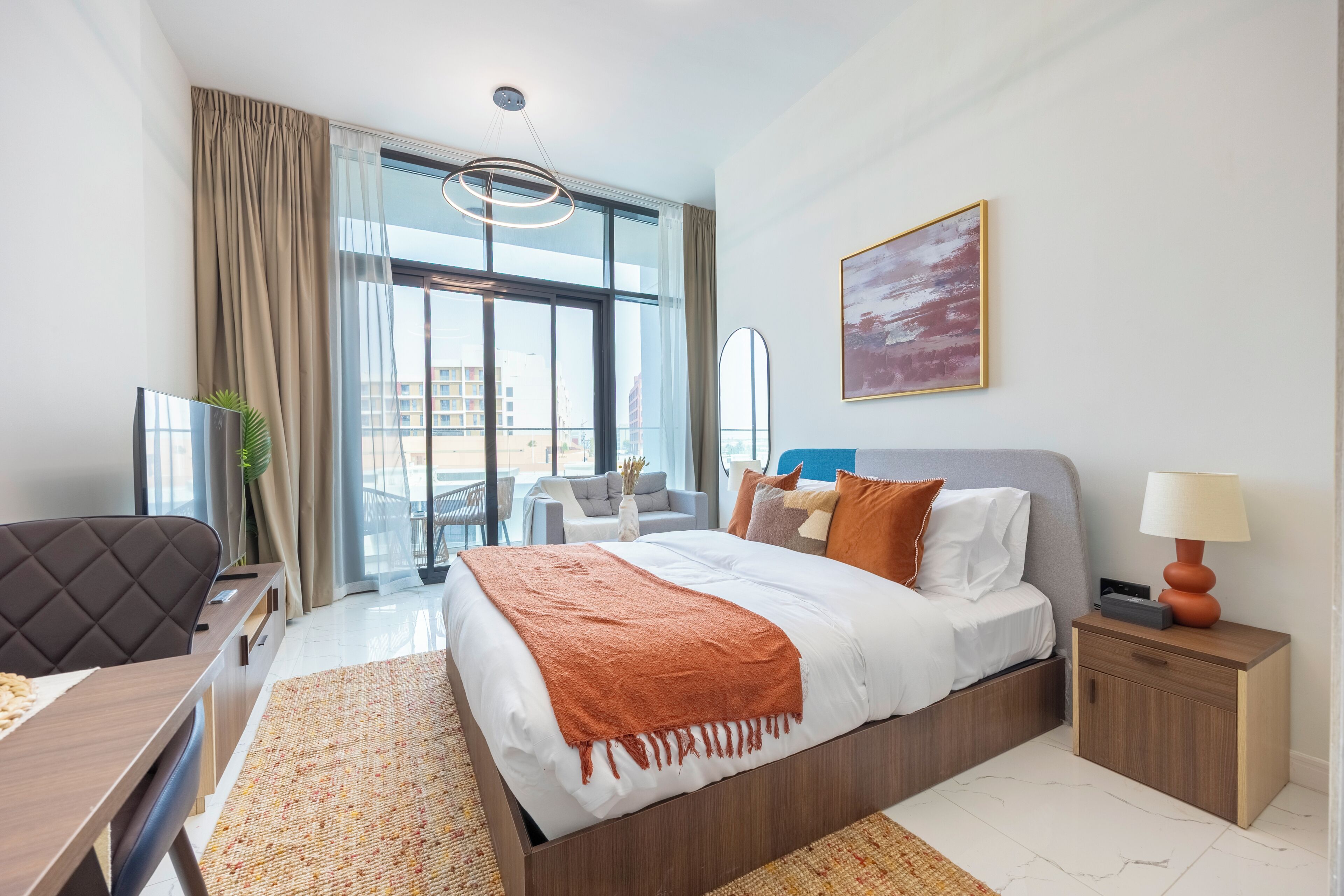 Una camera d'albergo moderna con un letto grande, una scrivania, una sedia, un comodino e vista sulla città.