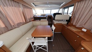 Een compact RV-interieur met een eetgedeelte, zitplaatsen en een kleine kitchenette.
