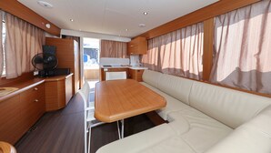 Een compact RV-interieur met een kitchenette, een eethoek en een zithoek.