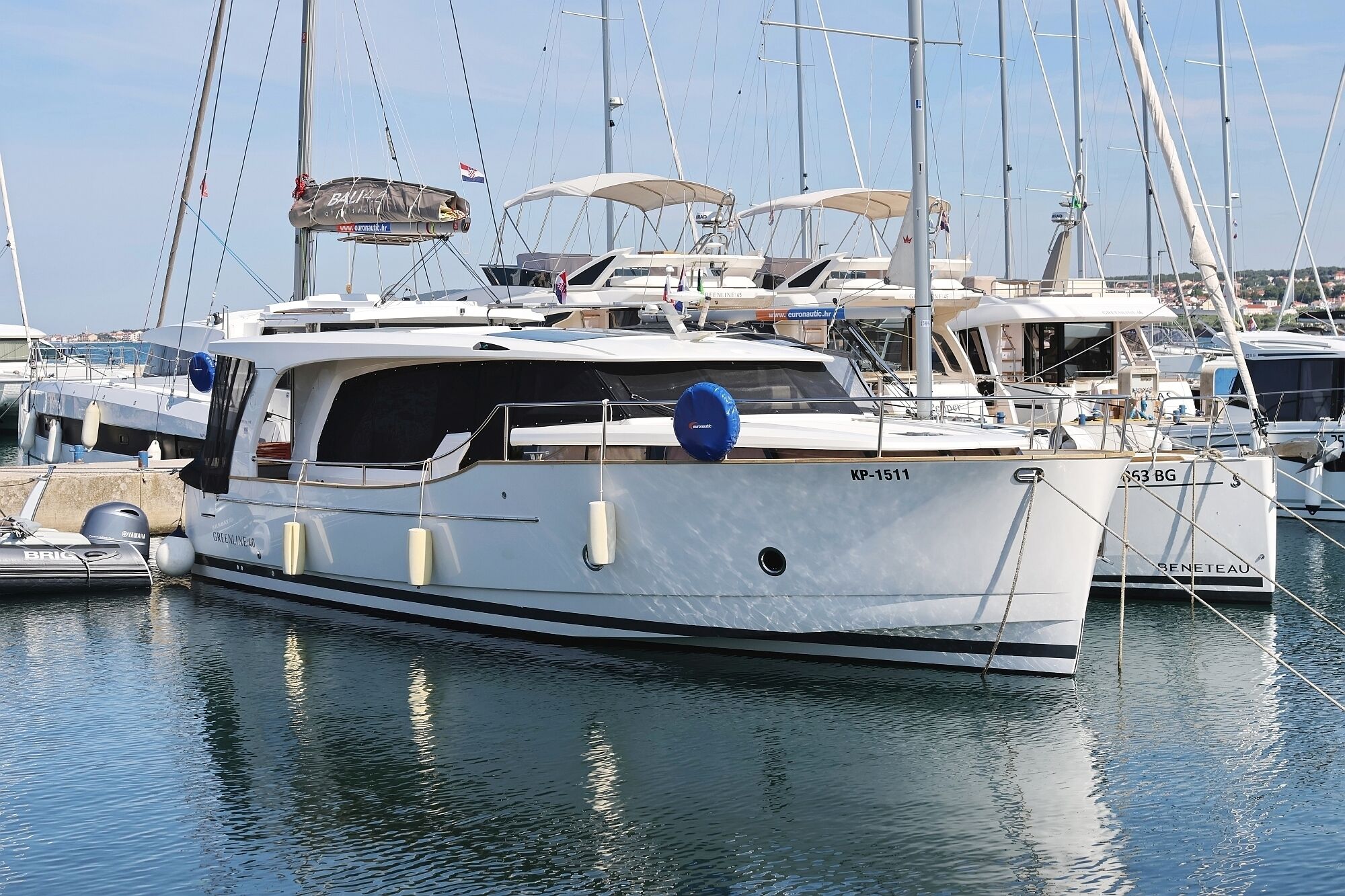 A marina with several yachts docked, including a boat named 'GREENLINE 40'.