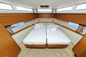 A cabin with two wooden beds, a central window, and a skylight. - Sibenik Sun-soaked Sailing: A Luxurious Croatian Voyage (Pirovac)