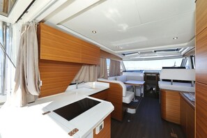 A compact, well-lit interior with a kitchenette, seating area, and a small table. - Sibenik Sun-soaked Sailing: A Luxurious Croatian Voyage (Pirovac)