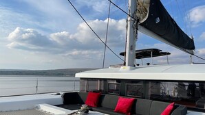 A boat deck with a seating area, a mast, and a view of the water. - Sun-Kissed Sailing Adventure in Northern Croatia (Punat)