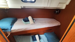 A compact RV interior with two bunk beds, a small window, and a compact kitchenette. - Caribbean Sun-Kissed Sailing: A Luxurious Beach Experience from Martinica, Le Marin (Le Marin)
