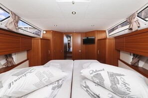 A cabin with two beds, wooden paneling, a TV, and a skylight. - Sun-Kissed Sailing Adventure in Zadar, Croatia (Biograd na moru)