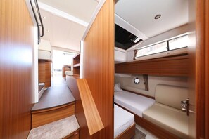 A compact RV interior with a kitchenette, a dining area, and a sleeping berth. - Sun-Kissed Sailing Adventure in Zadar, Croatia (Biograd na moru)