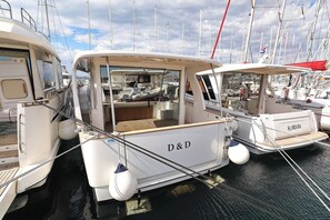 A white boat with 'D&D' on the side docked at a marina with other boats. - Sun-Kissed Sailing Adventure in Zadar, Croatia (Biograd na moru)