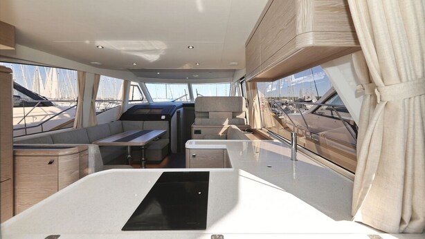 A boat interior with seating, a table, and windows offering views of the marina. - Sun-Kissed Sailing Adventure in Zadar, Croatia (Biograd na moru)