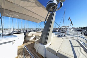 A marina with boats docked, a covered deck area with seating, and a mast with a radar. - Sun-Kissed Sailing Adventure in Zadar, Croatia (Biograd na moru)