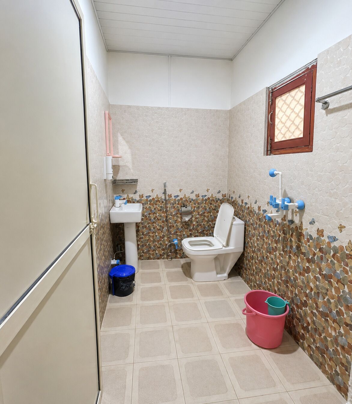 Un baño pequeño con inodoro, lavamanos y piso de baldosas.