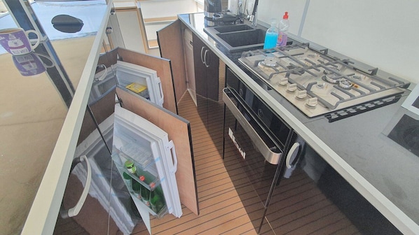 A compact kitchen with a gas stove, sink, and storage cabinets. - Sun-kissed Sailing Adventure in Split-Dalmatia, Croatia (Trogir)