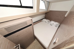 A compact RV interior with a bed, a small kitchenette, and a window. - Sun-Kissed Sailing Adventure in Zadar, Croatia (Biograd na moru)