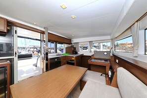 A compact kitchen with a wooden table and a built-in stove. - Sibenik Sun-soaked Sailing: A Luxurious Croatian Voyage (Pirovac)