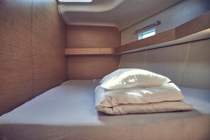 Una cama litera con un almohadón y cabecero.