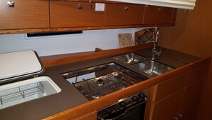 A compact kitchenette with a stove, sink, and storage cabinets. - Sun-Kissed Sailing Adventure in the Ionian Islands, Lefkada (Lefkada)