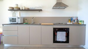 Una cuina moderna amb microones, forn i rentapesos integrats.