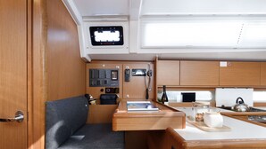 Une cuisine compacte dotée d’un plan de travail en bois, d’une cuisinière intégrée et d’un petit évier.